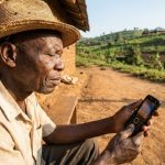 Agriculteur camerounais consultant un contenu simple sur un téléphone à faible débit