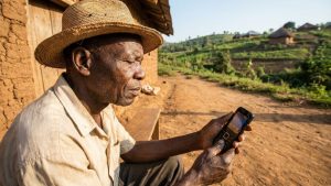 Agriculteur camerounais consultant un contenu simple sur un téléphone à faible débit